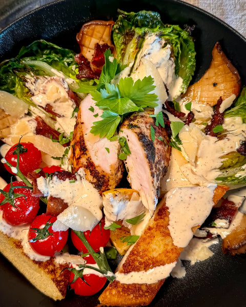 Gegrillter Caesar Salad mit Hähnchenbrust, Bacon, Tomaten, Knoblauchbrot und Pilzen