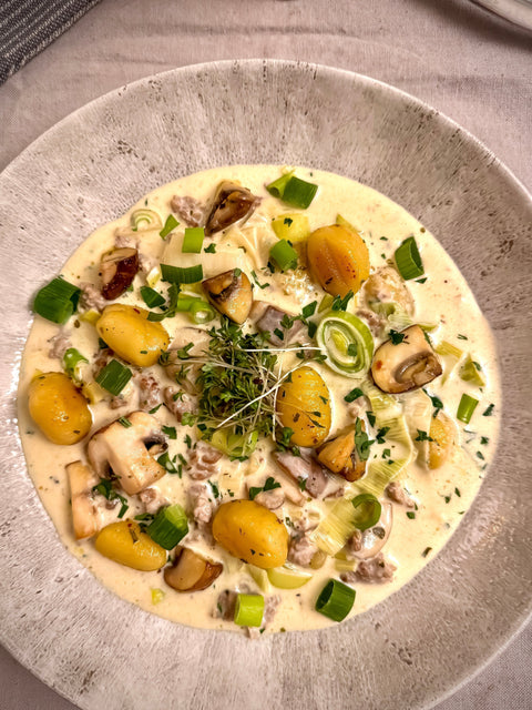 Rustikaler Eintopf mit Gnocchi, Hackfleisch, Champignons und Lauch in cremiger Käsesoße