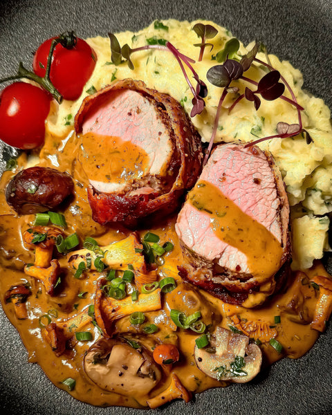 Schweinefilet im Speckmantel mit Pfifferlingen und Champignons in Café de Paris Sauce auf Kartoffelstampf