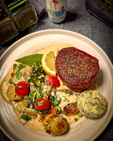 In Parmaschinken gewickeltes Filetsteak vom Rind mit Kräuterbutter und gratinierten Florentiner Kartoffeln