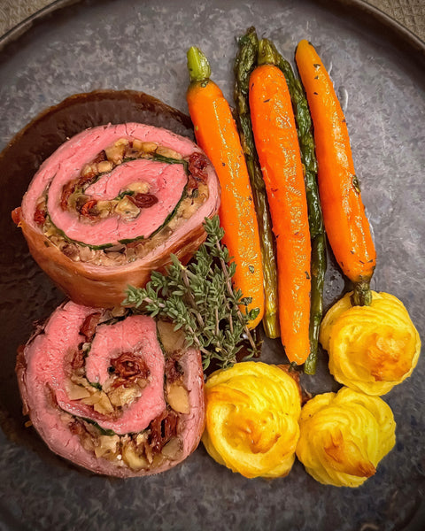 Gefülltes Flanksteak mit Walnüssen und Maronen auf Rotweinjus, glasierten Möhren, Spargel und Herzoginkartoffeln