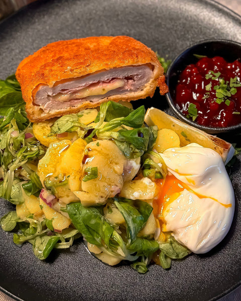 Knuspriges Cordon Bleu aus dem Schweinerücken mit österreichischem Erdäpfel-Vogerlsalat und pochiertem Ei