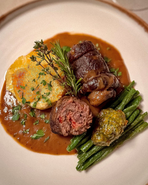 Rinderinvoltini gefüllt mit Parmaschinken und Paprika in Rotweinsoße, dazu Kartoffelgratin und grüne Bohnen