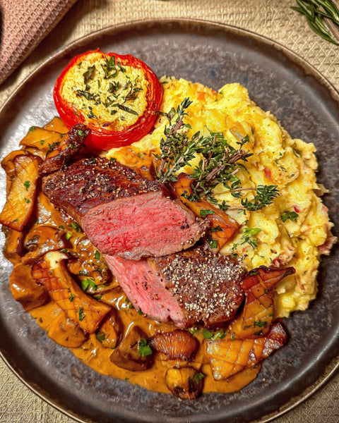 Rumpsteak mit Pfifferlingen und Champignons in Whisky-Rahmsauce, dazu Kartoffelstampf mit Bacon und gefüllter Tomate