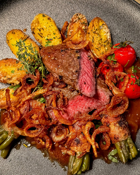 Klassischer Zwiebelrostbraten vom Hüftsteak mit Bohnen im Speckmantel und goldenen Parmesankartoffeln