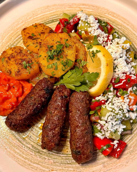 Selbst gemachte Cevapcici mit Schopska Salat, Bratkartoffeln und Ajvar